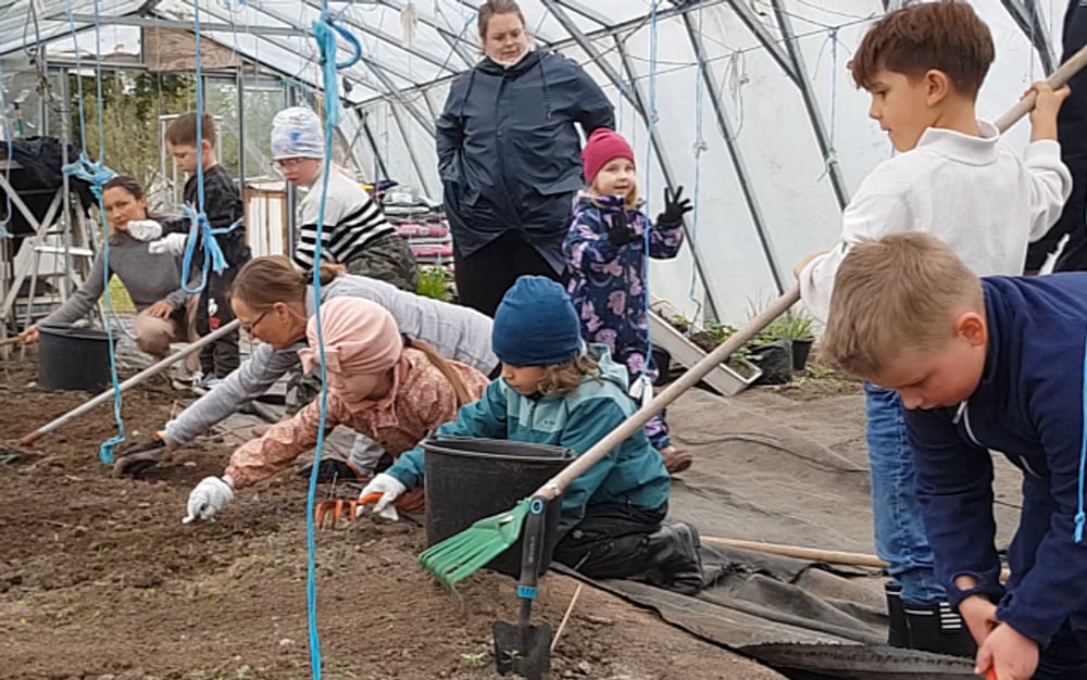 Barn som odlar tillsammans i grupp. Vi ser plantering och skörd.