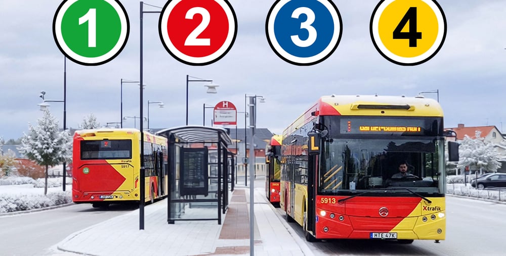 Två stadsbussar från X-trafik står vid en hållplats i vintermiljö.