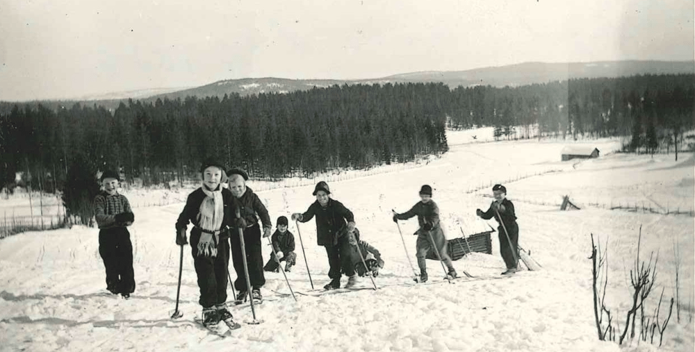 En grupp människor som står på toppen av en snötäckt sluttning.