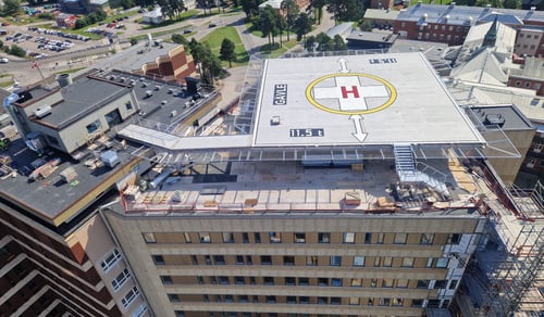 Bilden visar den nya helikopterplattan på taket av hus 60. Helikopterplattan är fortfarande en byggarbetsplats. Bilden visar också en del av den ny tillbyggnaden av 6 våningar och den nya fasaden på den södra sidan av byggnaden. 